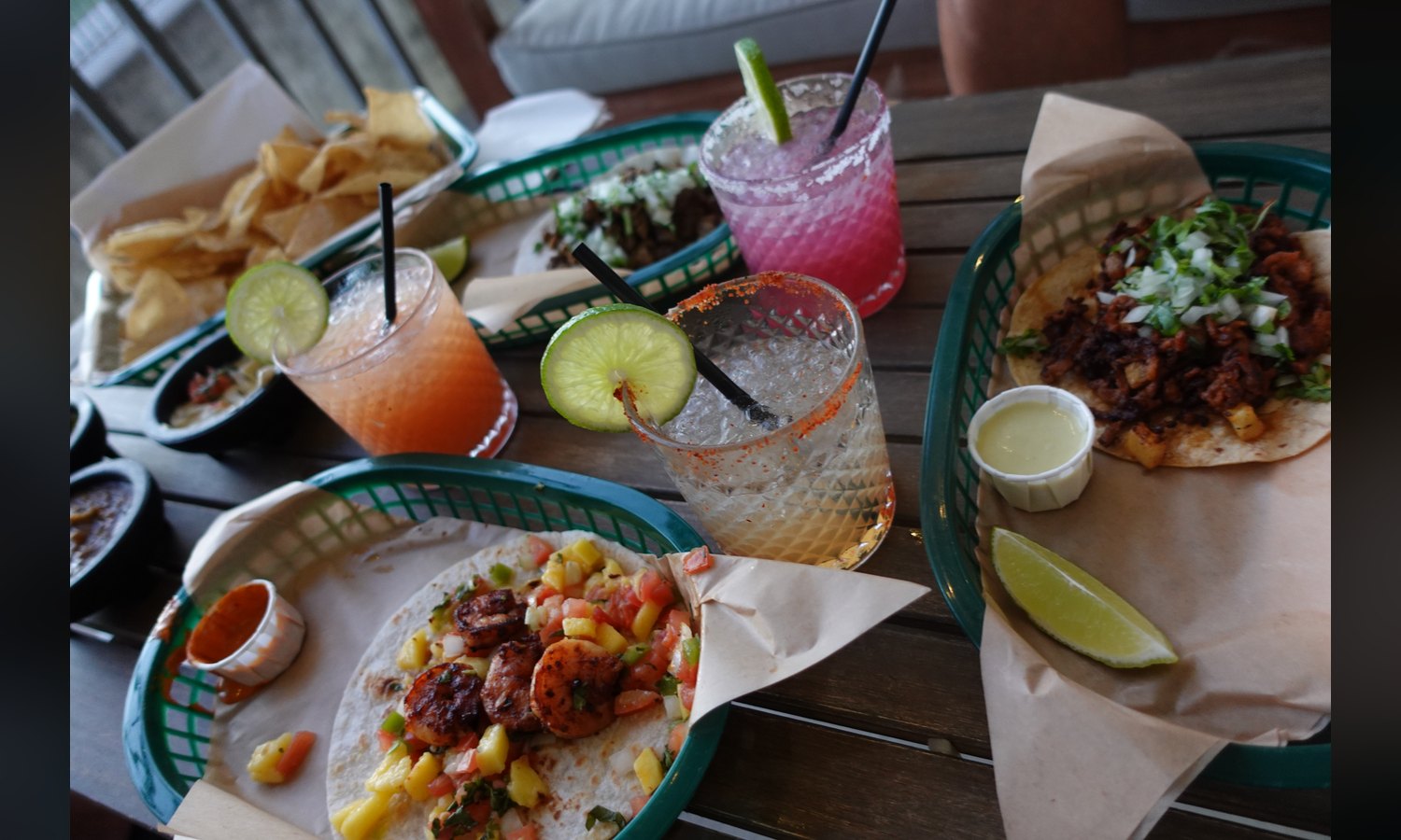 A table on the Fairways patio. Blackened shrimp with mango pico on the left, al pastor with pineapple on the right.