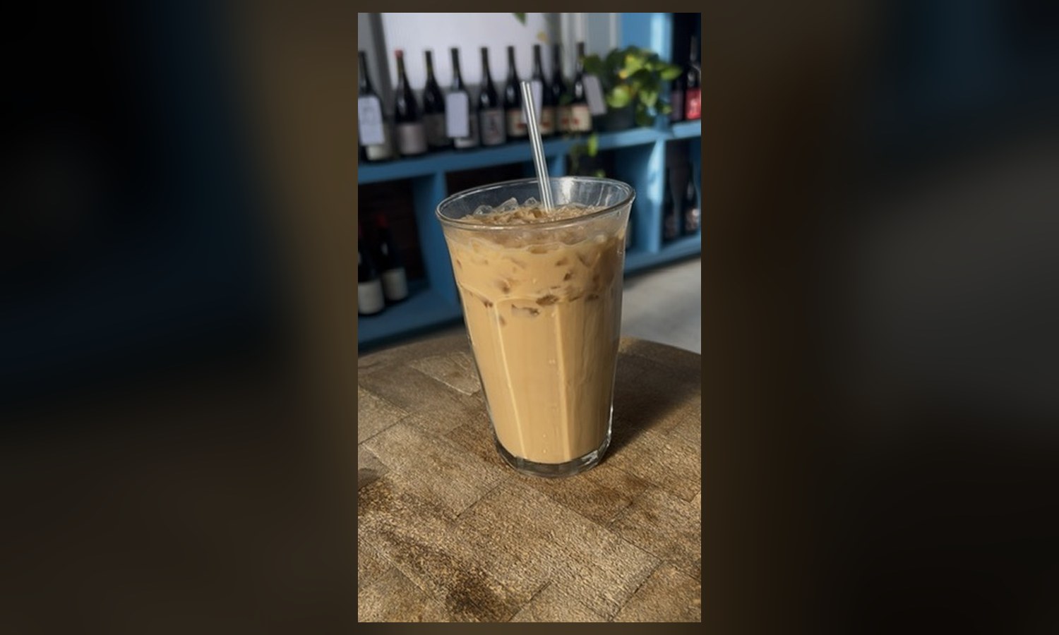 The iced latte, in front of the wine shelf it will be sharing the room with in eight hours